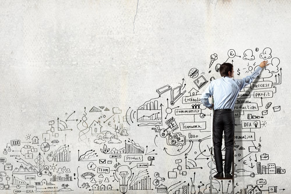 Back view of businessman drawing sketch on wall